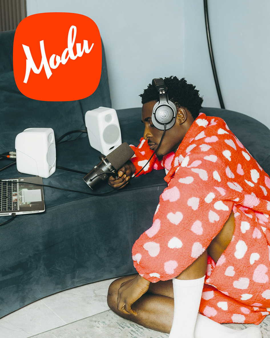 Creator with headphones and a mic in front of computer